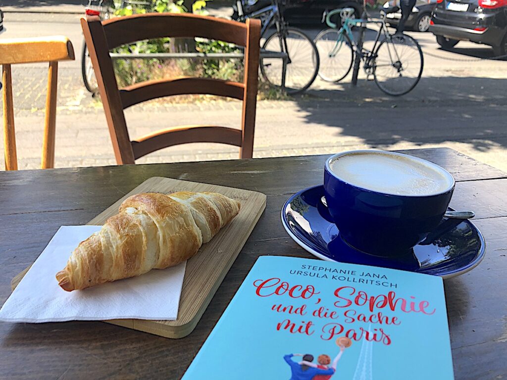 Perfekte Bücher an perfekten Orten - Paris-Roman mit Croissant.